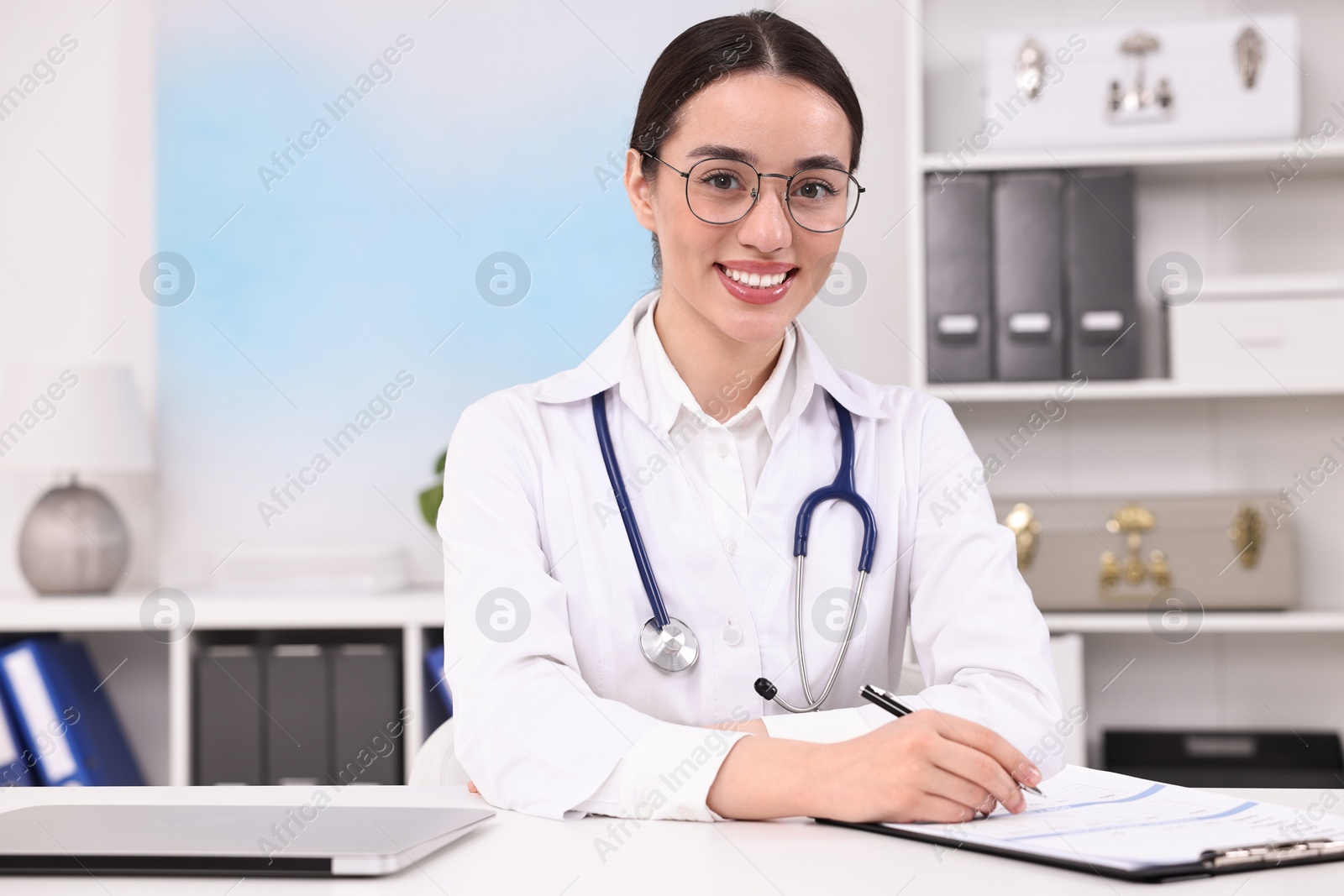 Photo of Medical consultant with stethoscope at table in clinic