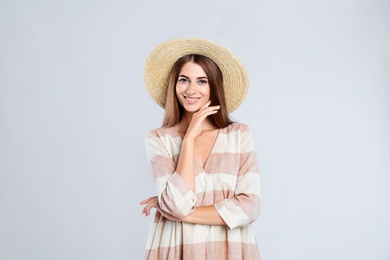 Young woman wearing stylish dress on light grey background