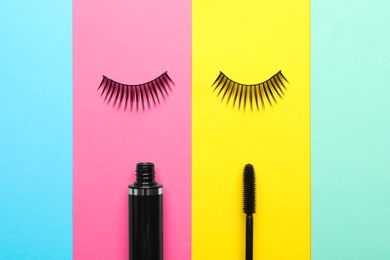 False eyelashes and mascara on color background, flat lay