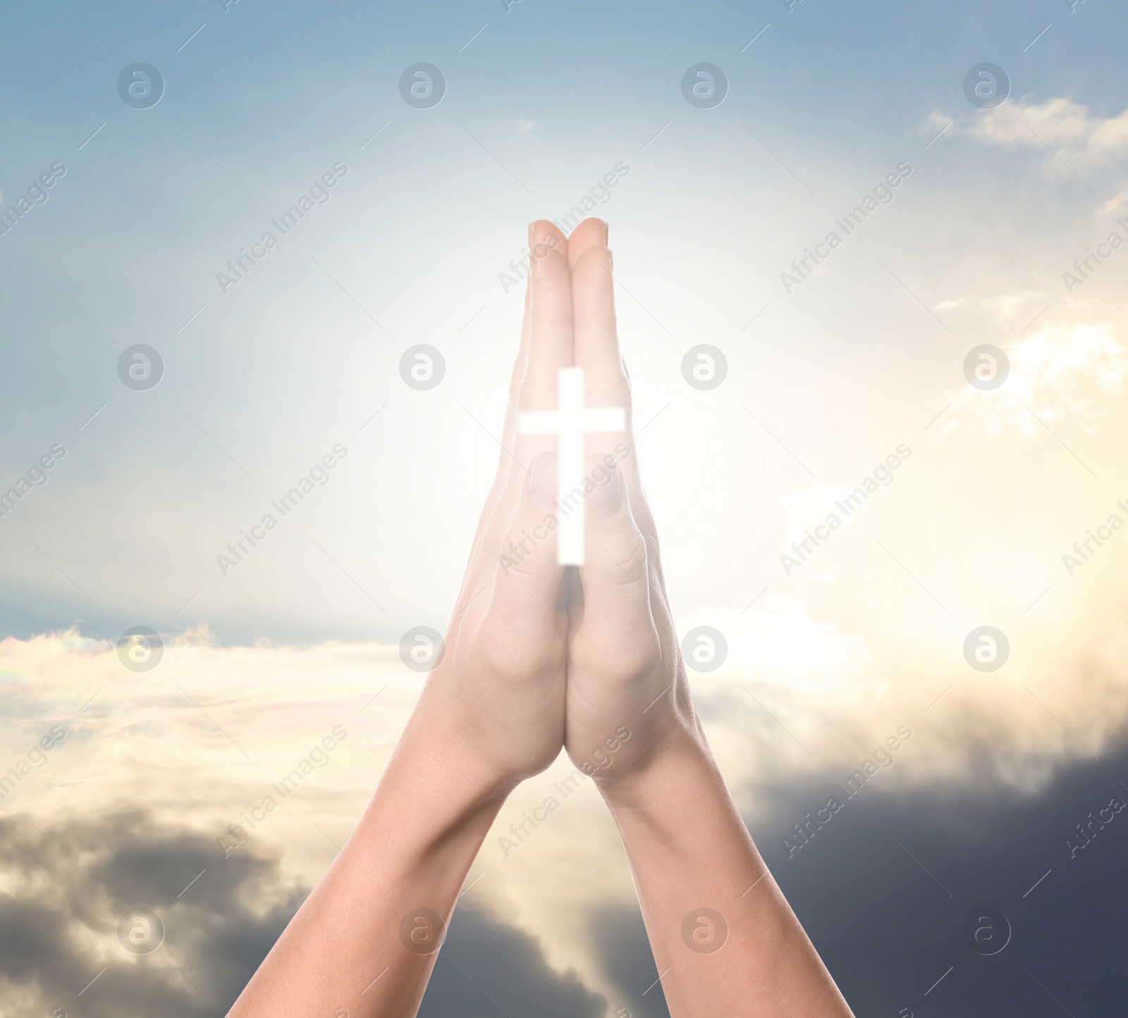 Image of Religion. Christian woman with glowing cross praying against sky, closeup