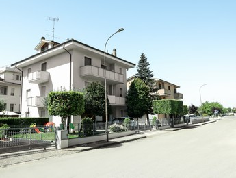 Photo of Residential building with green trees on city street