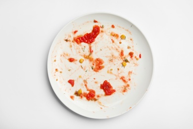 Photo of Dirty plate with food leftovers on white background, top view