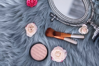 Photo of Flat lay composition with makeup brushes, roses and mirror on faux fur