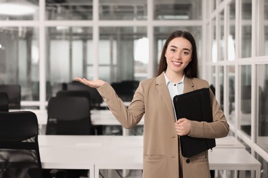 Happy real estate agent with leather portfolio in office