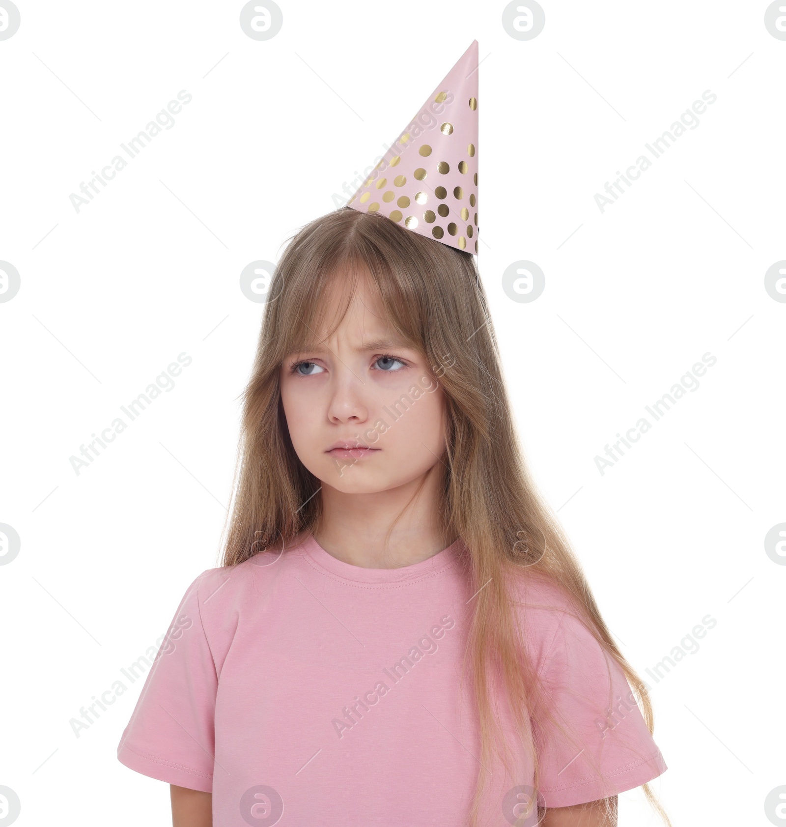Photo of Unhappy little girl in party hat on white background