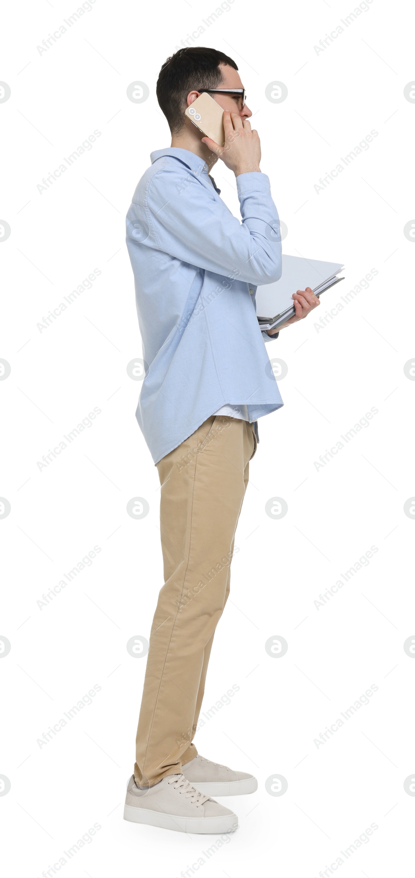 Photo of Young man in glasses holding folders and talking on mobile phone on white background