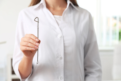 Photo of Speech therapist with logopedic probe in clinic, closeup