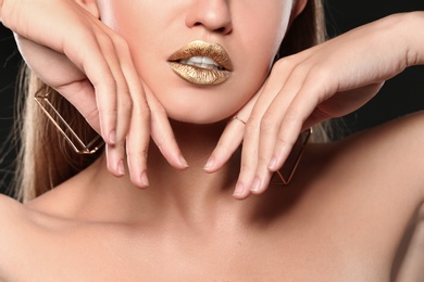 Photo of Beautiful lady with gold shiny lipstick, closeup