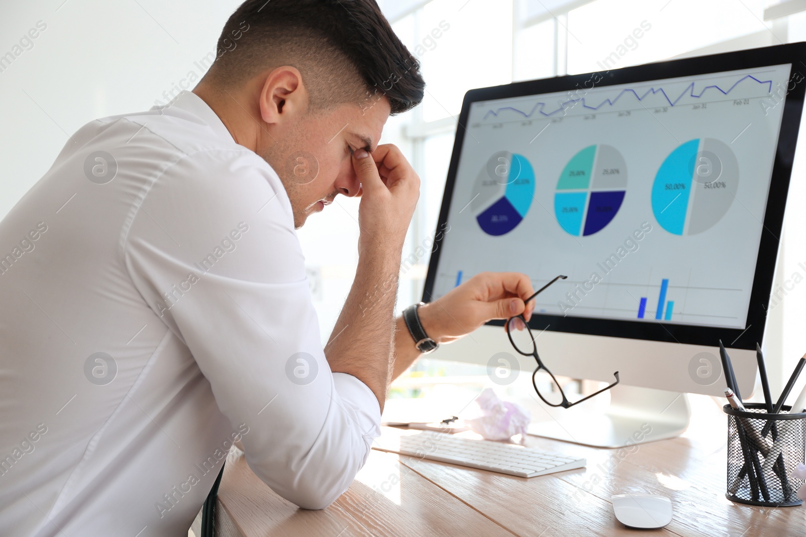 Photo of Businessman stressing out at workplace in office