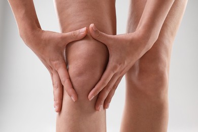 Photo of Woman showing her slim legs on grey background, closeup