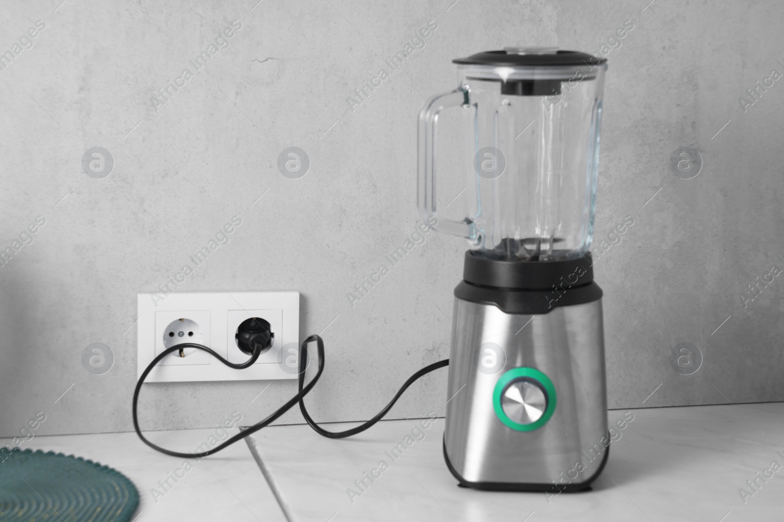 Photo of Electric blender plugged into power socket on white table