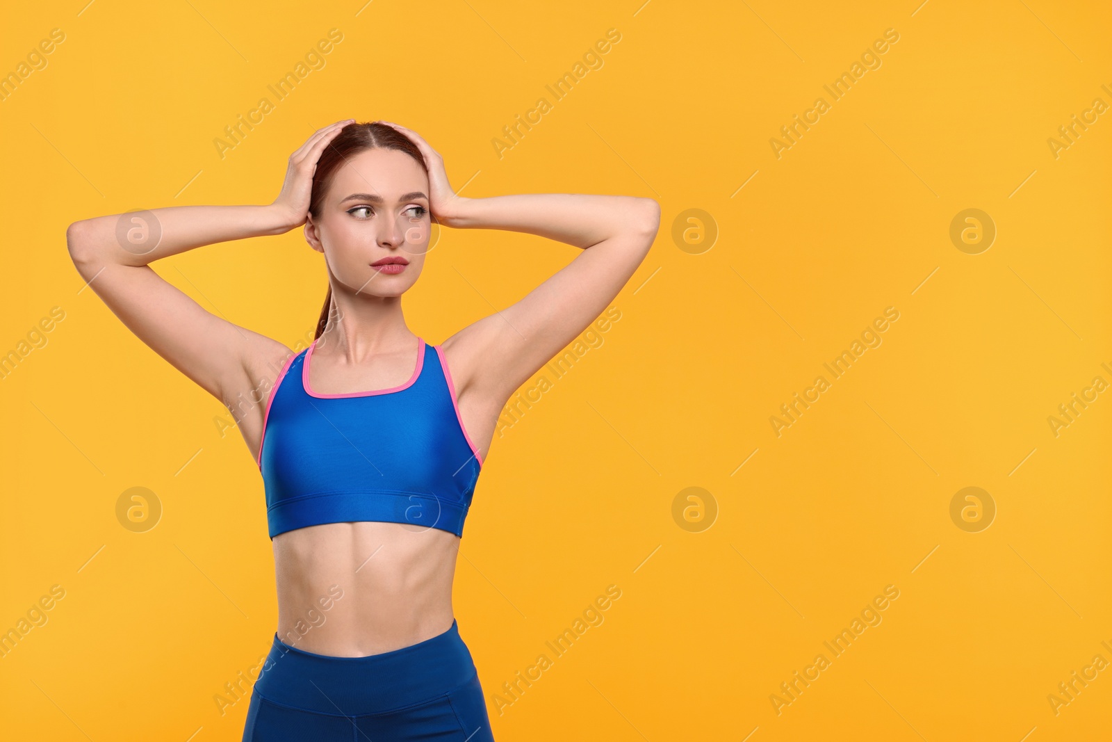 Photo of Young woman wearing sportswear on yellow background, space for text