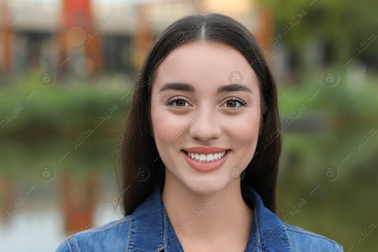 Photo of Portrait of beautiful woman outdoors. Attractive lady smiling and looking into camera