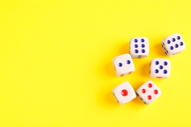 Photo of Many white game dices on yellow background, flat lay. Space for text