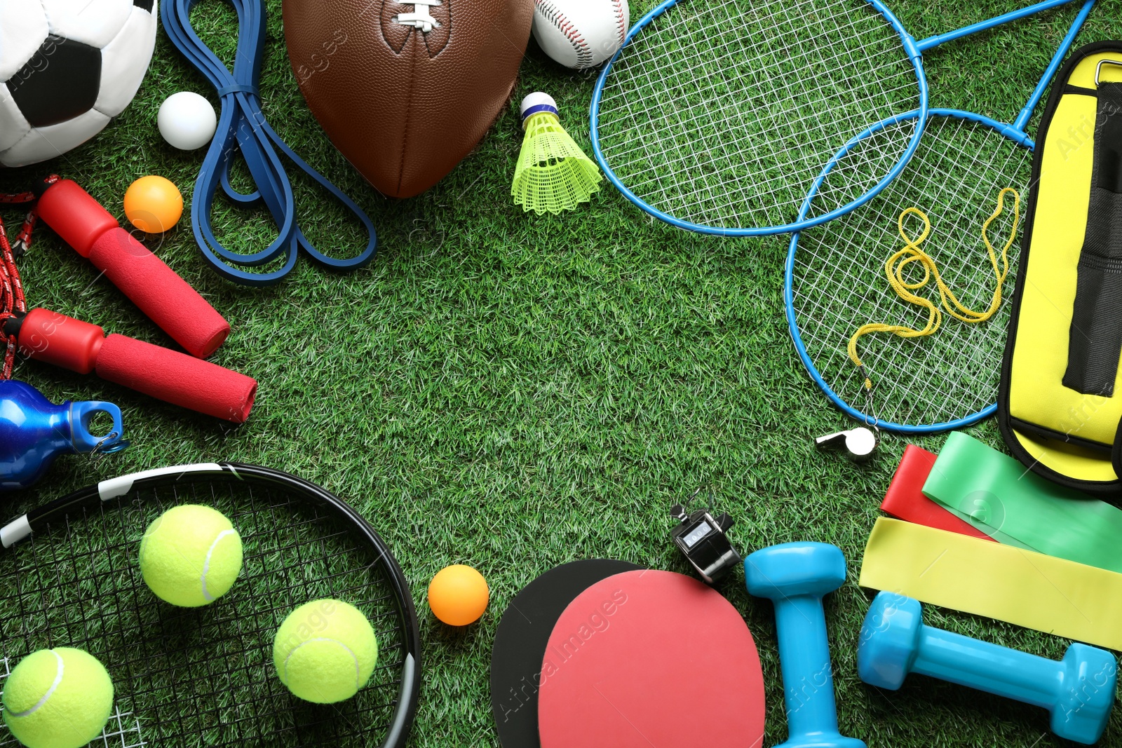 Photo of Set of different colorful sports equipment on green grass, flat lay. Space for text