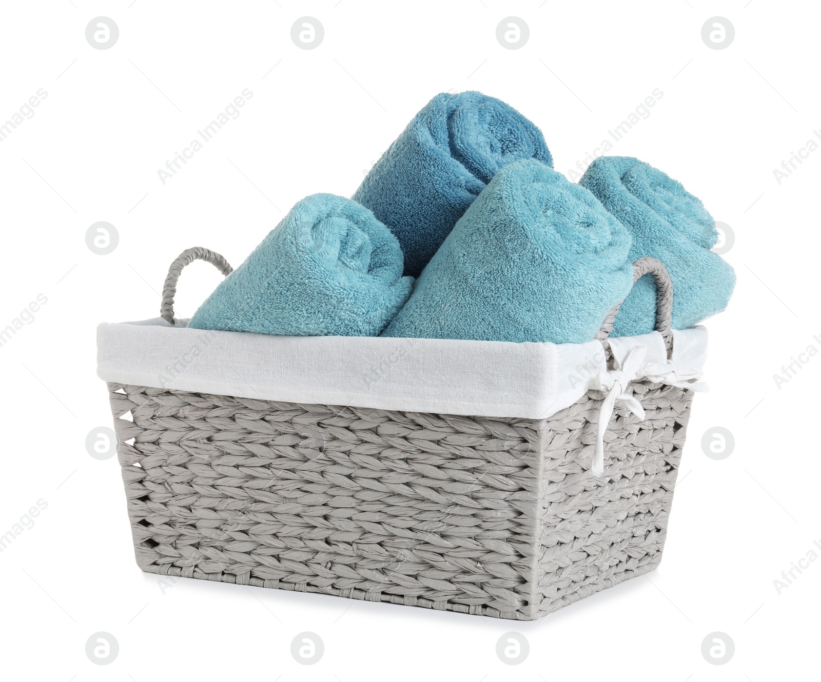 Photo of Rolled soft towels in basket on white background