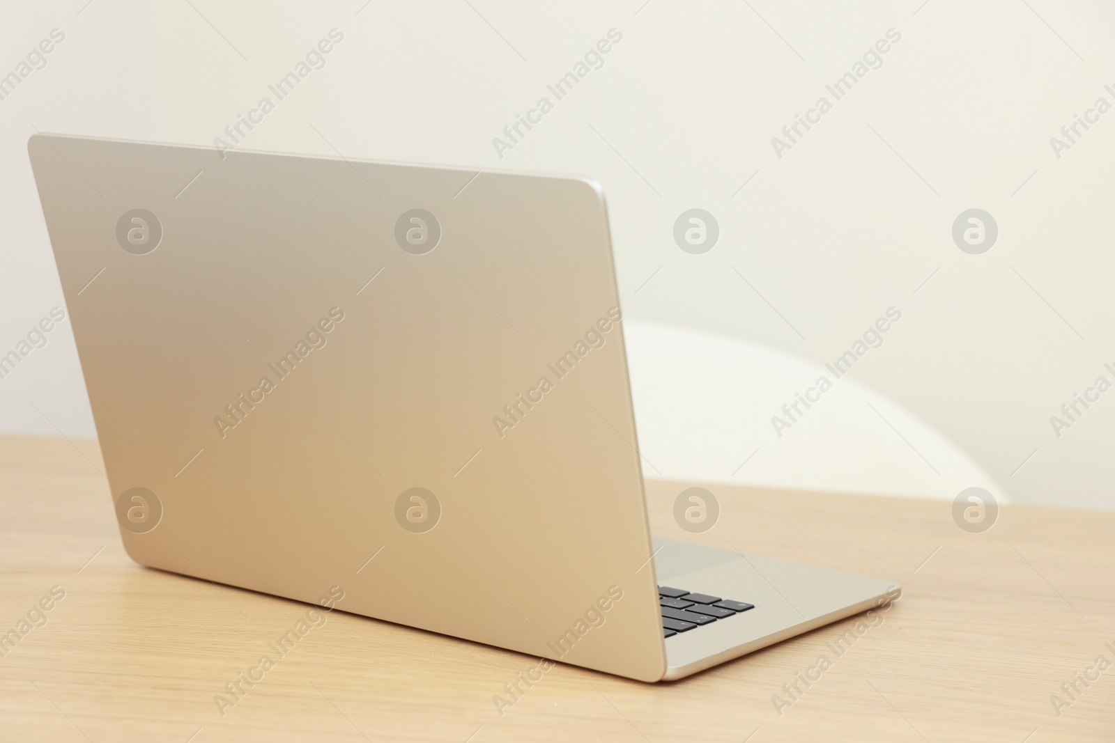 Photo of Modern laptop on wooden table. Space for text