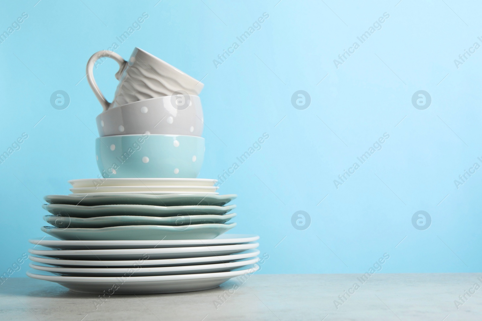 Photo of Beautiful ceramic dishware and cup on light grey table, space for text