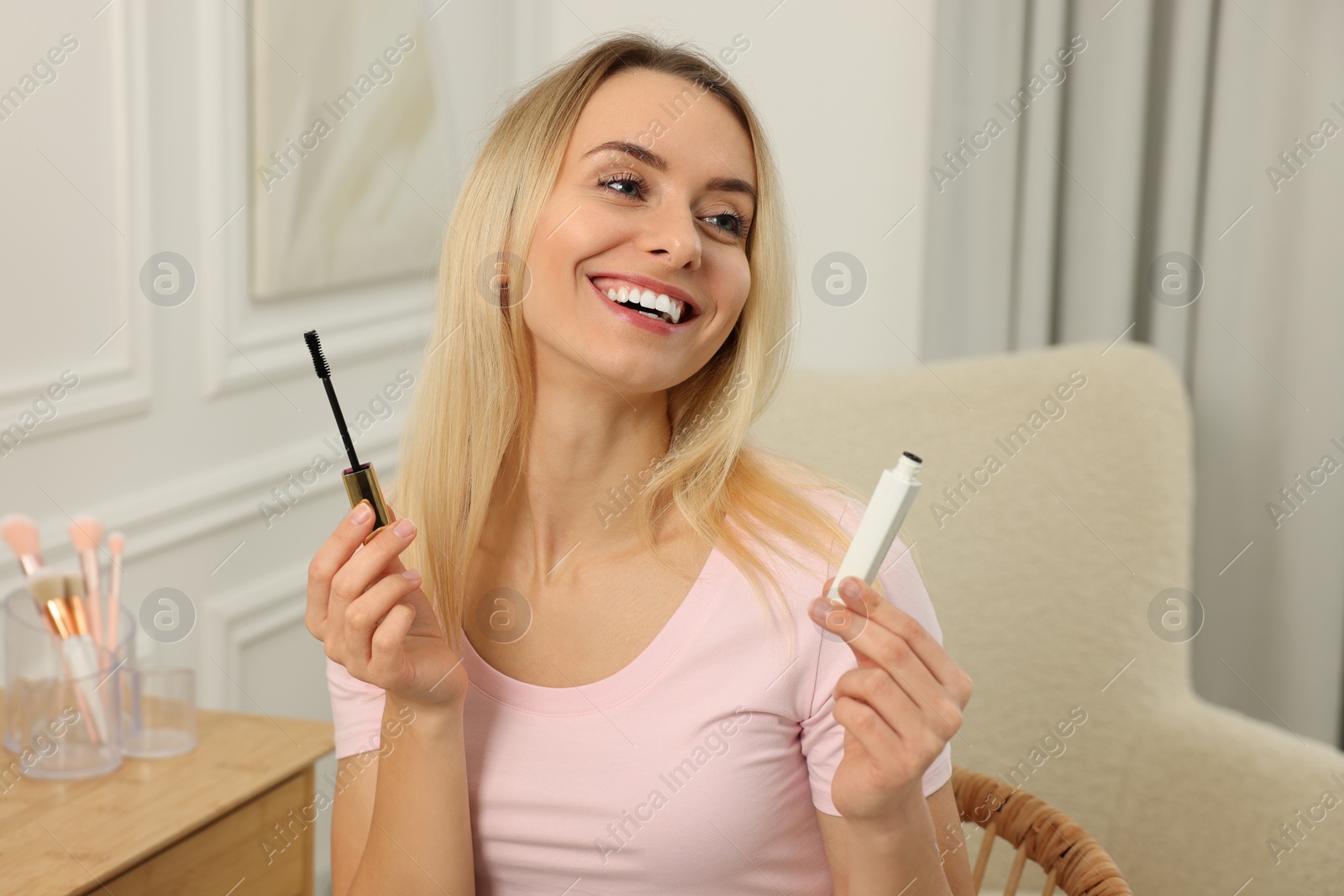 Photo of Beautiful happy woman with mascara at home