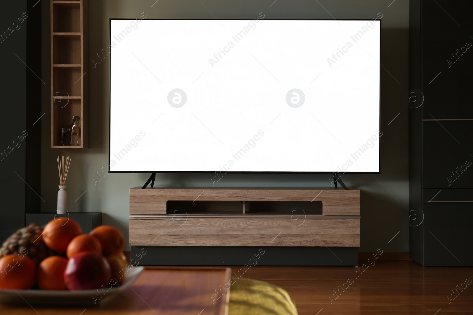 Photo of Modern TV set on table in room. Interior design