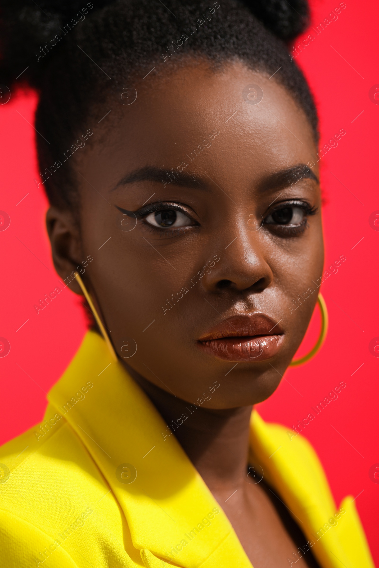 Photo of Fashionable portrait of beautiful woman on coral background, closeup