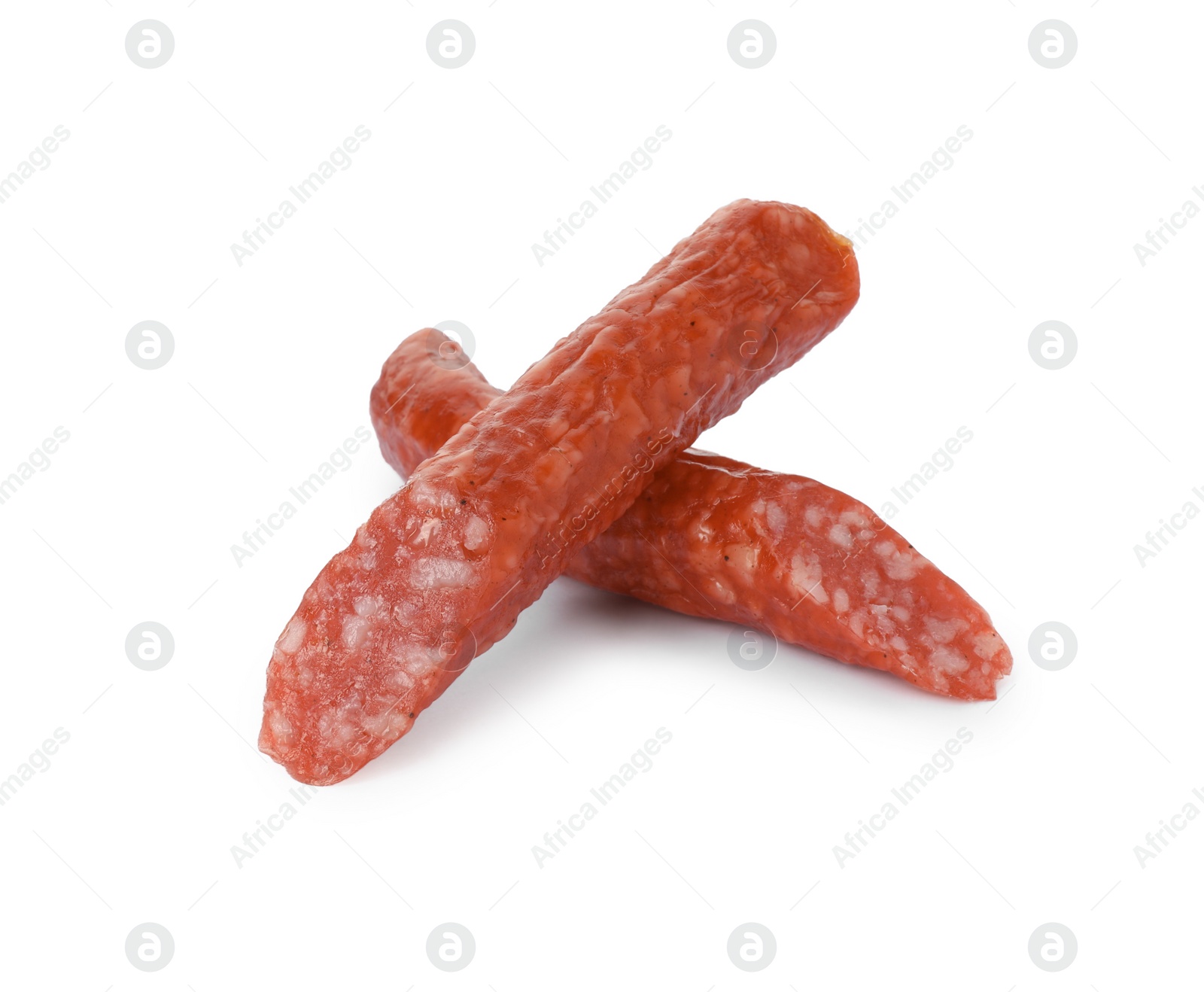 Photo of Pieces of thin dry smoked sausage isolated on white