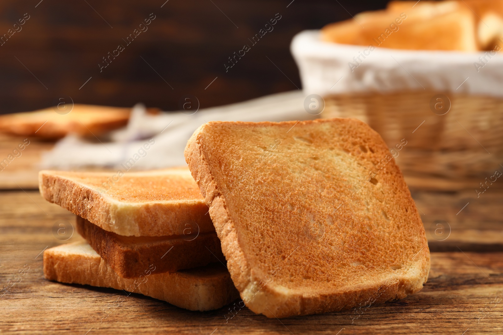 Photo of Slices of tasty toasted bread on wooden table, closeup