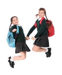 Photo of Cute girls in school uniform jumping on white background