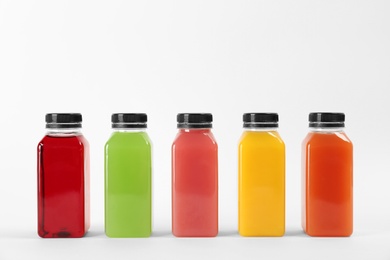 Bottles with delicious colorful juices on white background