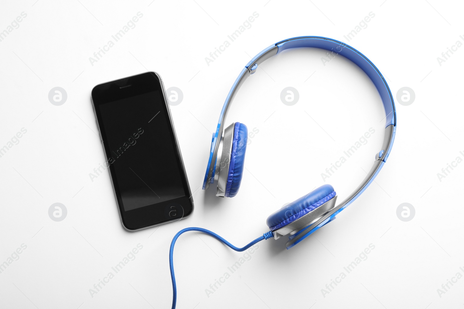 Photo of Stylish headphones and modern phone on white background, top view. Space for text