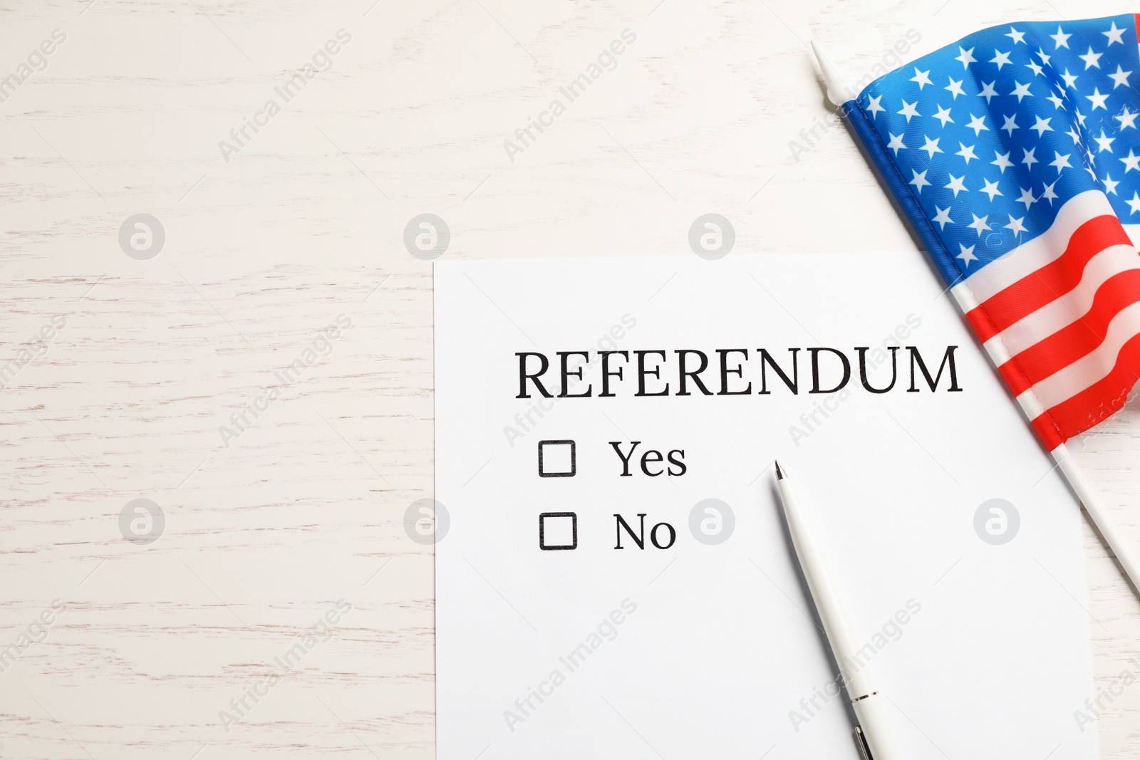 Photo of Referendum ballot with pen and flag of USA on white wooden table, flat lay. Space for text