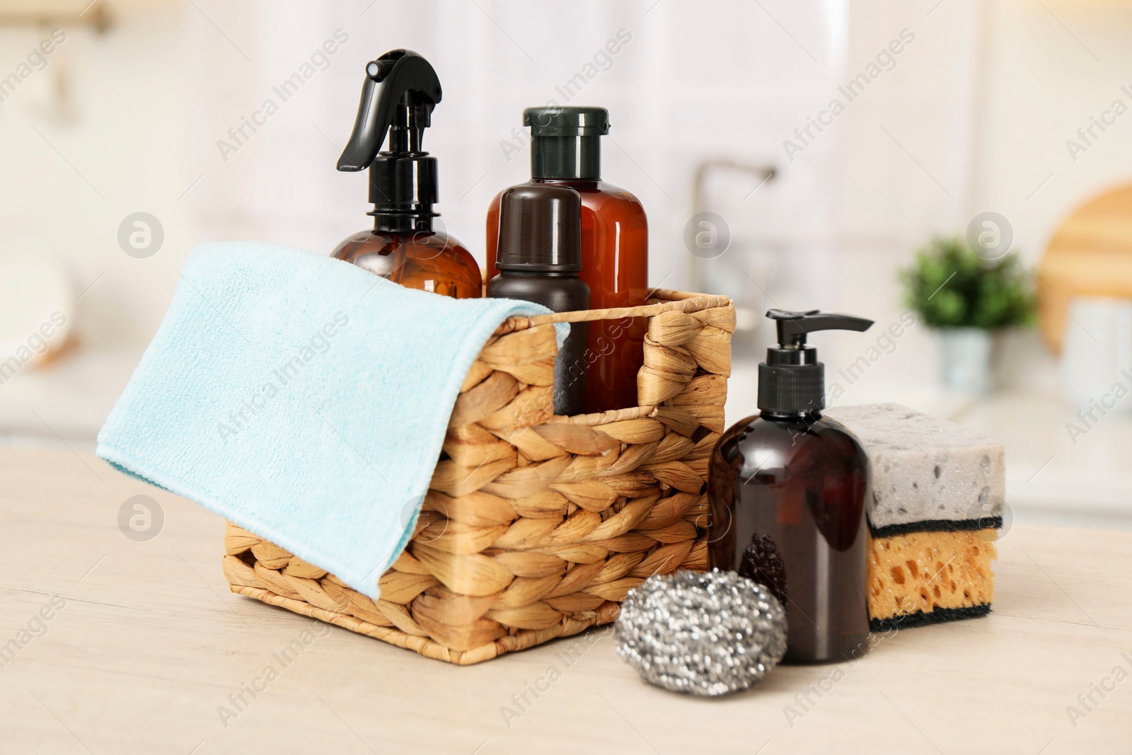 Photo of Different cleaning supplies in basket on table