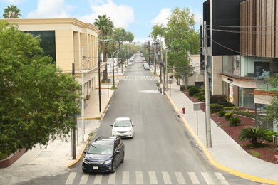 Photo of Mexico, San Pedro Garza Garcia - August 26, 2022: City street with modern cars, buildings and palms