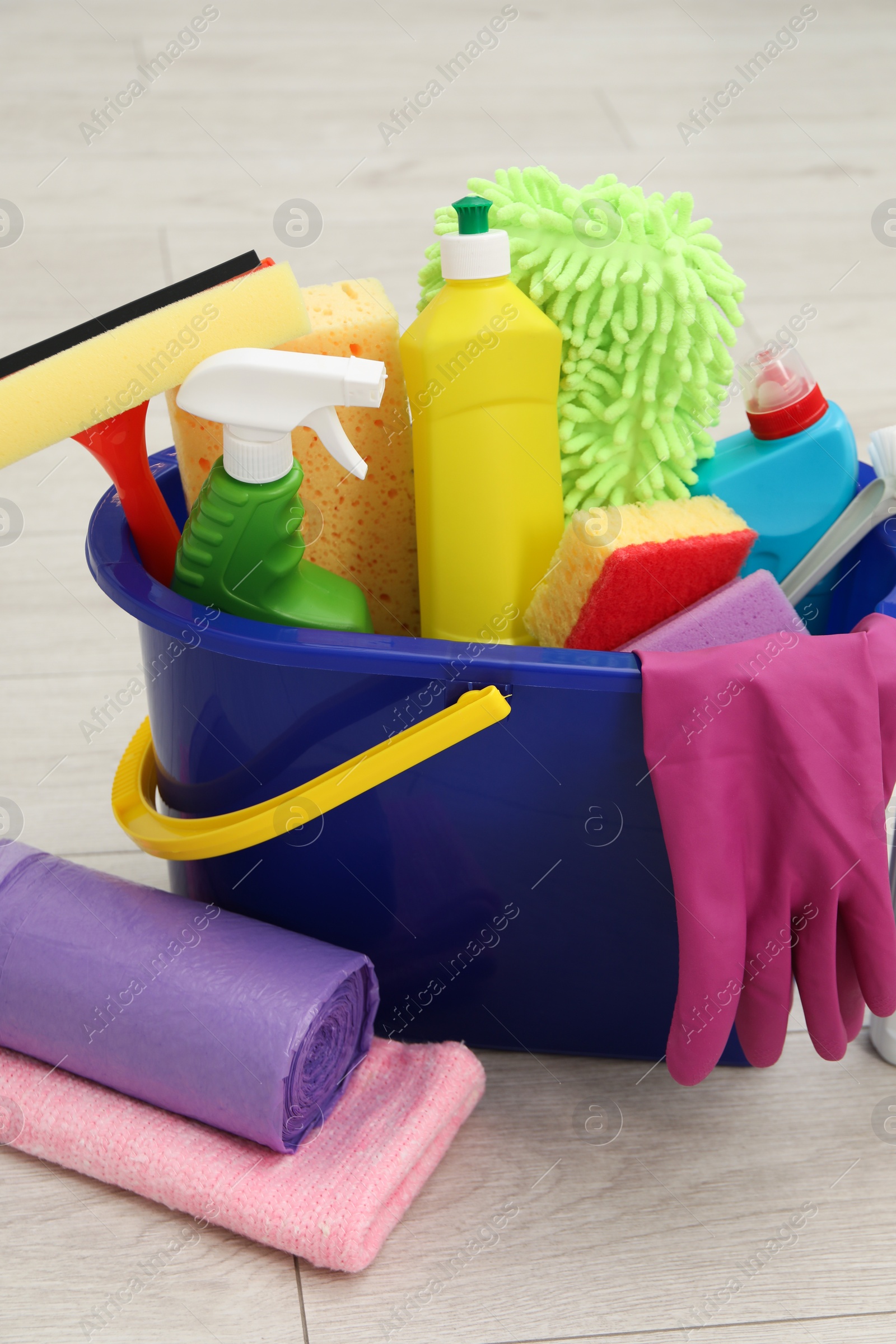 Photo of Different cleaning supplies in bucket on floor