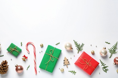 Flat lay composition with Christmas gifts and festive decor on white background. Space for text