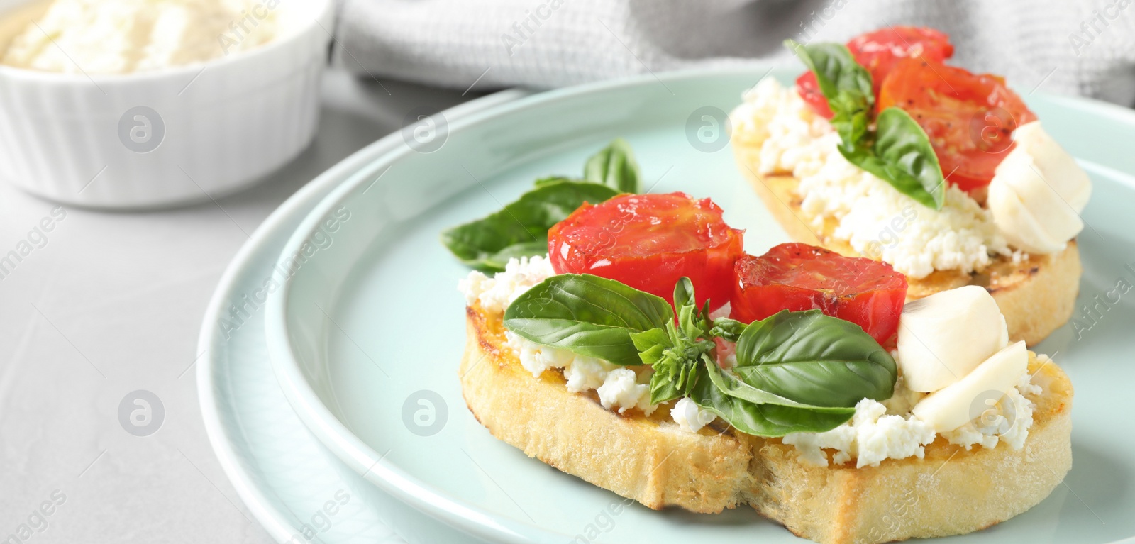 Image of Tasty bruschettas with tomato on grey table, closeup. Banner design 