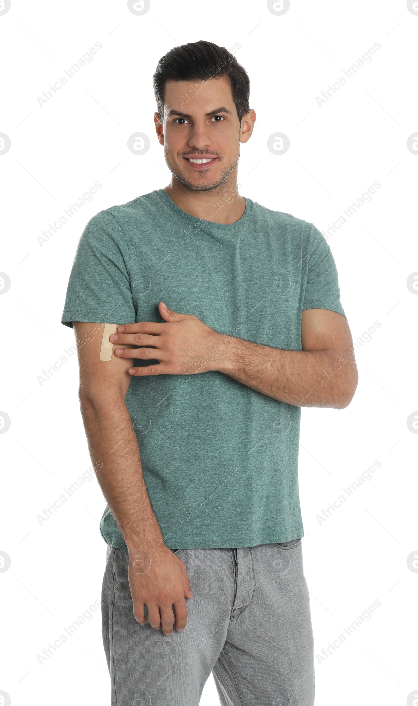 Photo of Happy man with sticking plaster on arm against white background