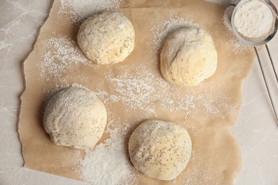 Photo of Fresh raw dough with poppy seeds and flour on table, top view