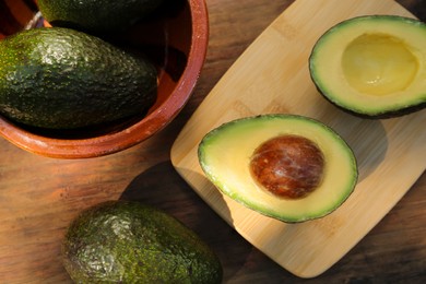 Tasty fresh avocados on wooden table, flat lay