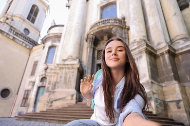 Photo of Beautiful travel blogger streaming outdoors, low angle view