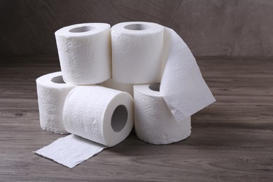 Photo of Soft toilet paper rolls on wooden table