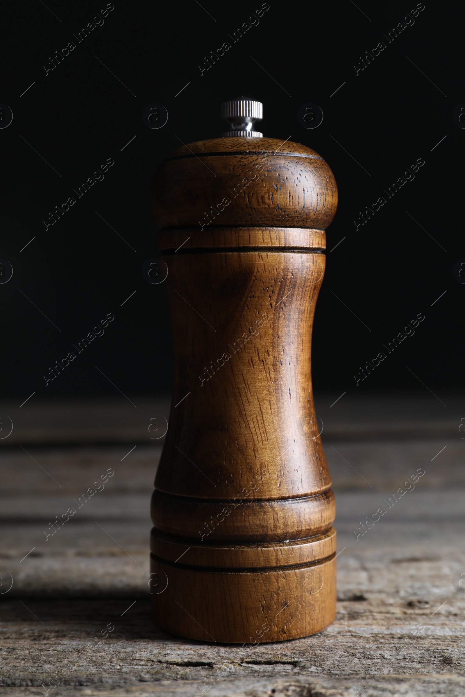 Photo of Salt or pepper shaker on wooden table, closeup