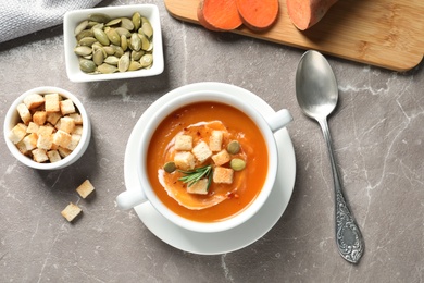 Flat lay composition with bowl of sweet potato soup on table