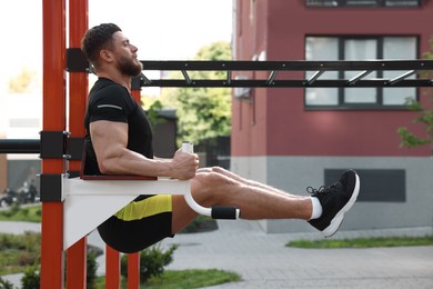 Man doing leg rise exercise at outdoor gym