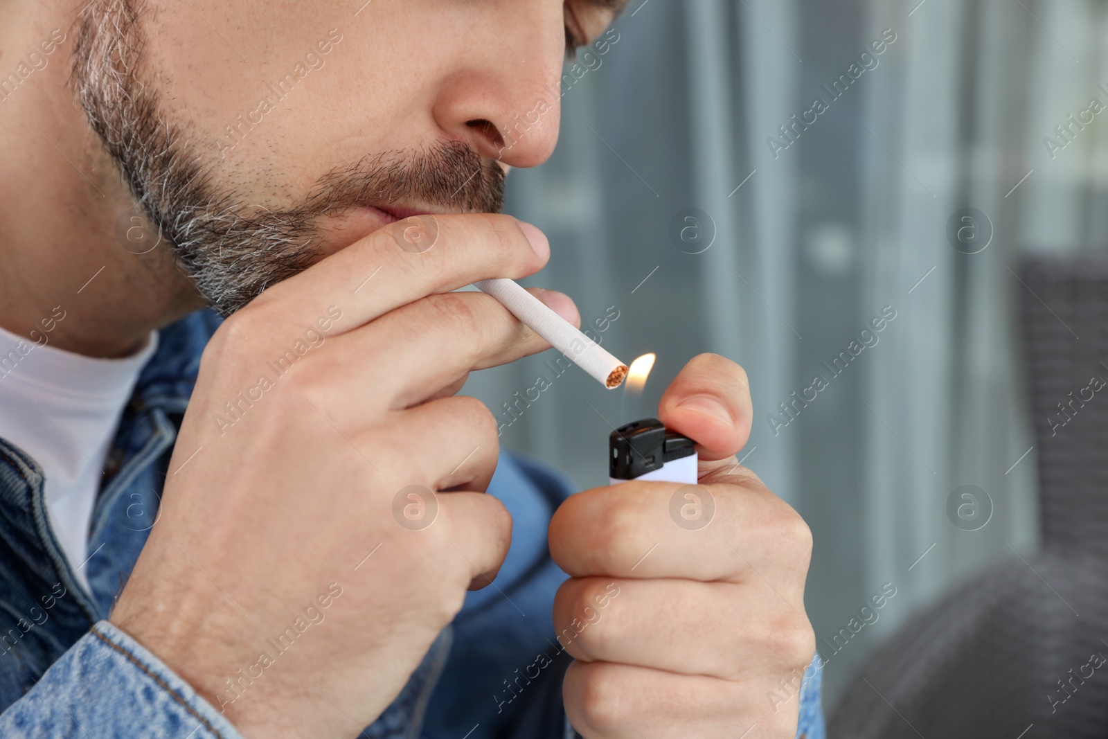 Photo of Mature man lighting cigarette, closeup of hands