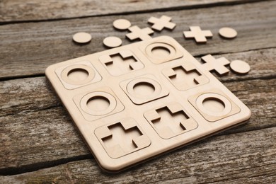 Photo of Tic tac toe set on wooden table, closeup