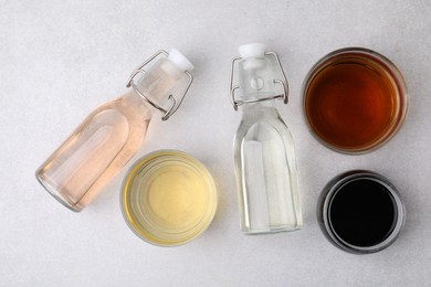 Photo of Different types of vinegar on light table, flat lay