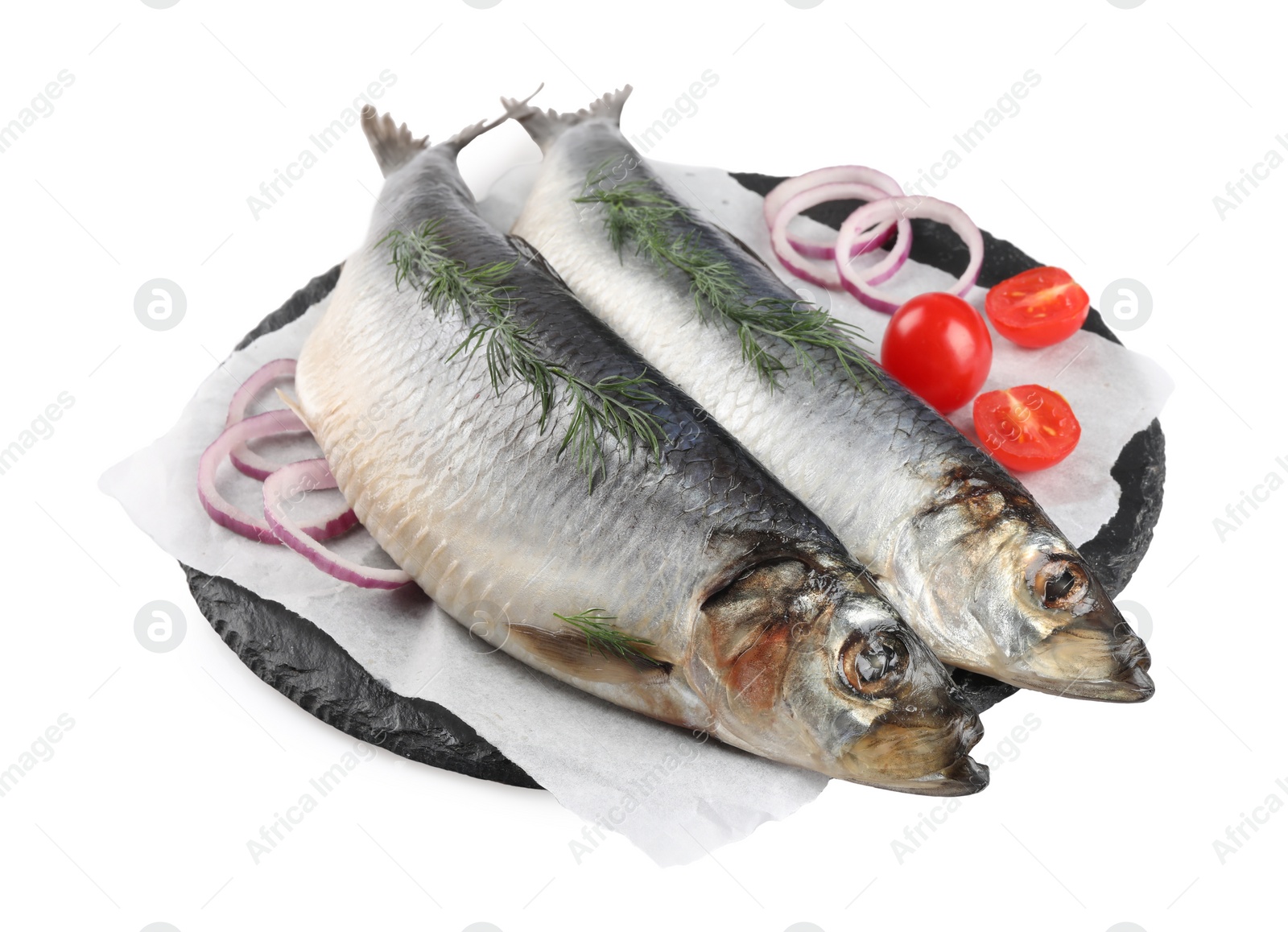 Photo of Slate plate with salted herrings, onion rings, dill and cherry tomatoes isolated on white