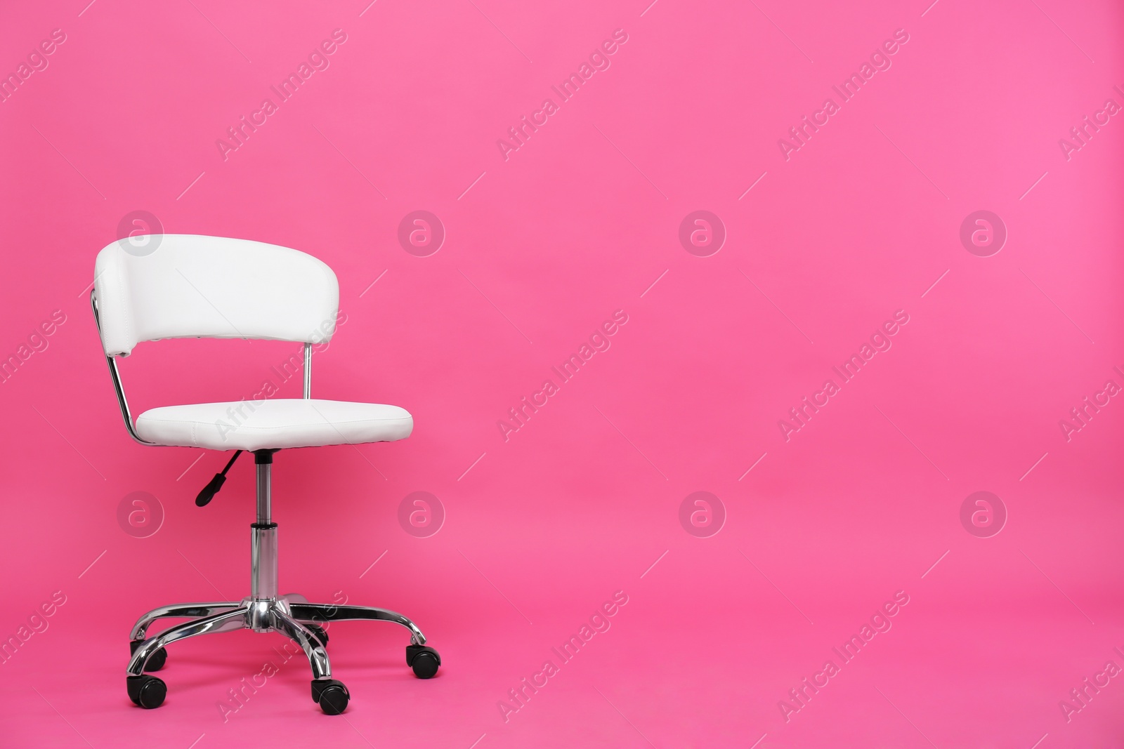 Photo of Comfortable office chair on pink background, space for text