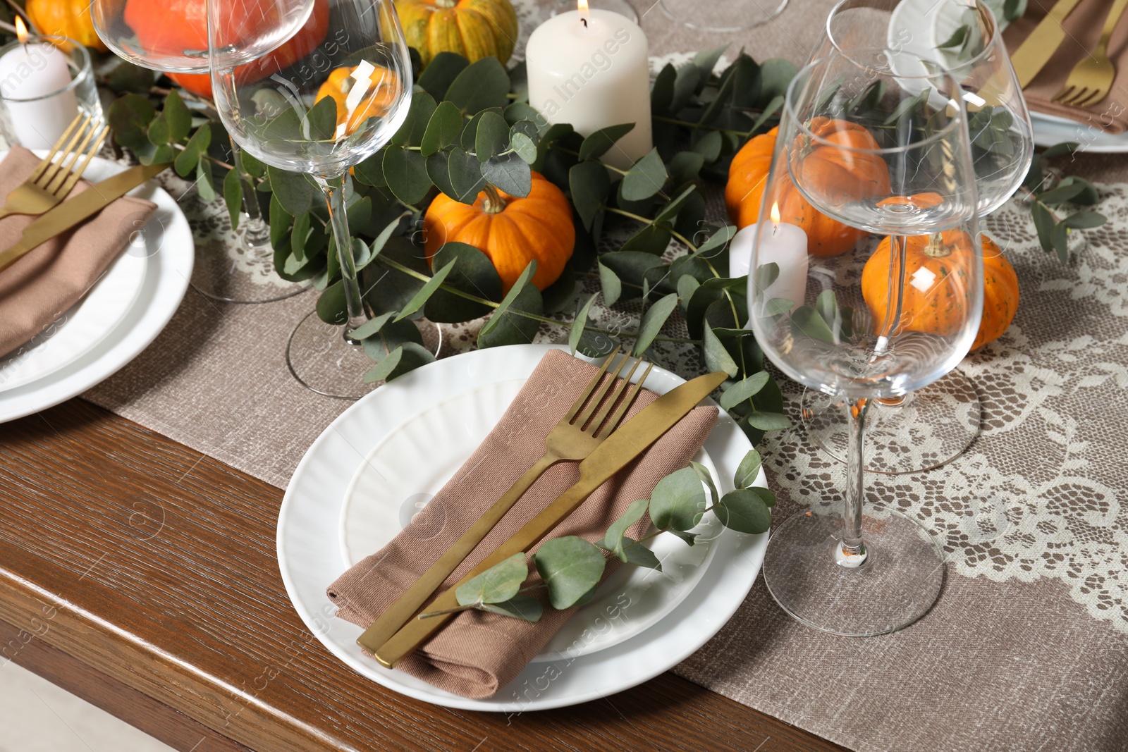 Photo of Beautiful autumn table setting. Plates, cutlery, glasses, pumpkins and floral decor